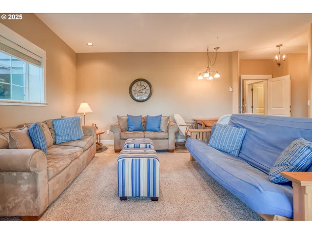 a living room with furniture a clock on wall and a window