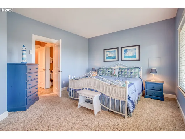 a bedroom with a bed next to a window and dresser