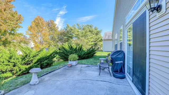 a view of a chair and table in backyard of the house