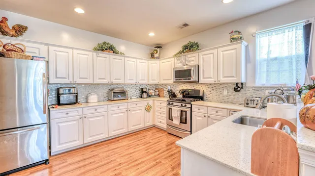 a large kitchen with stainless steel appliances granite countertop a stove a sink dishwasher and a refrigerator