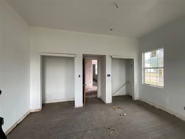 an empty room with windows and closet