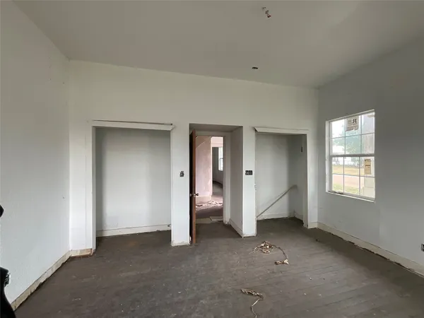 an empty room with windows and closet