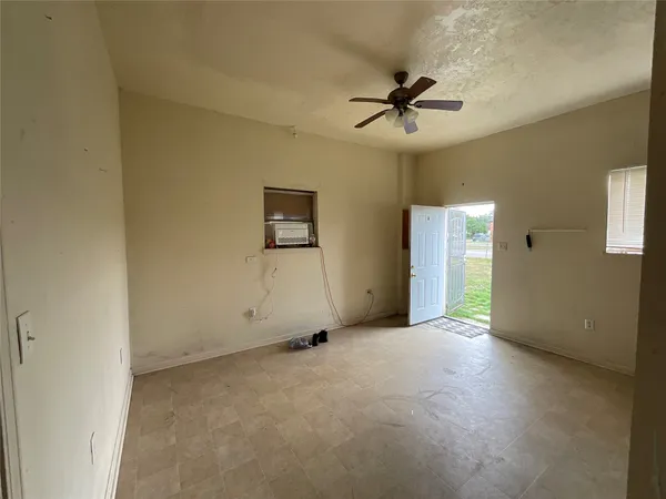 an empty room with windows and fan