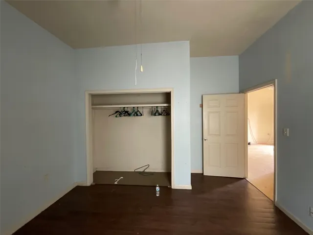 an empty room with wooden floor and closet