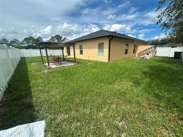 a view of a house with backyard and garden