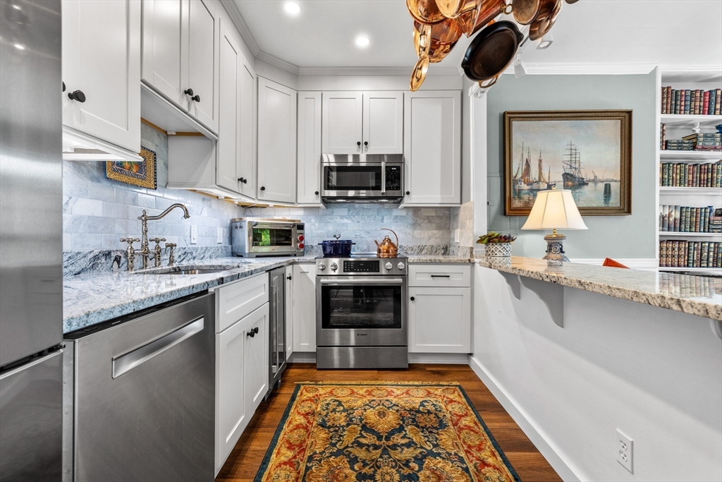 a kitchen with stainless steel appliances granite countertop a sink and stove top oven