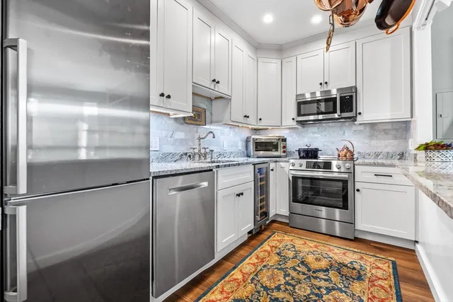 a kitchen with stainless steel appliances granite countertop a refrigerator sink and stove