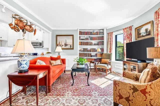 a living room with furniture a flat screen tv and a bookshelf