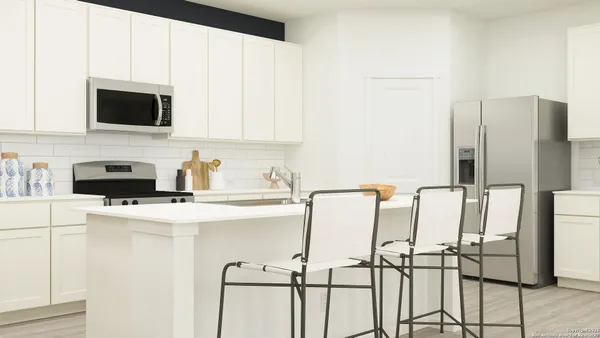 a kitchen with stainless steel appliances a stove a refrigerator sink and white cabinets with wooden floor