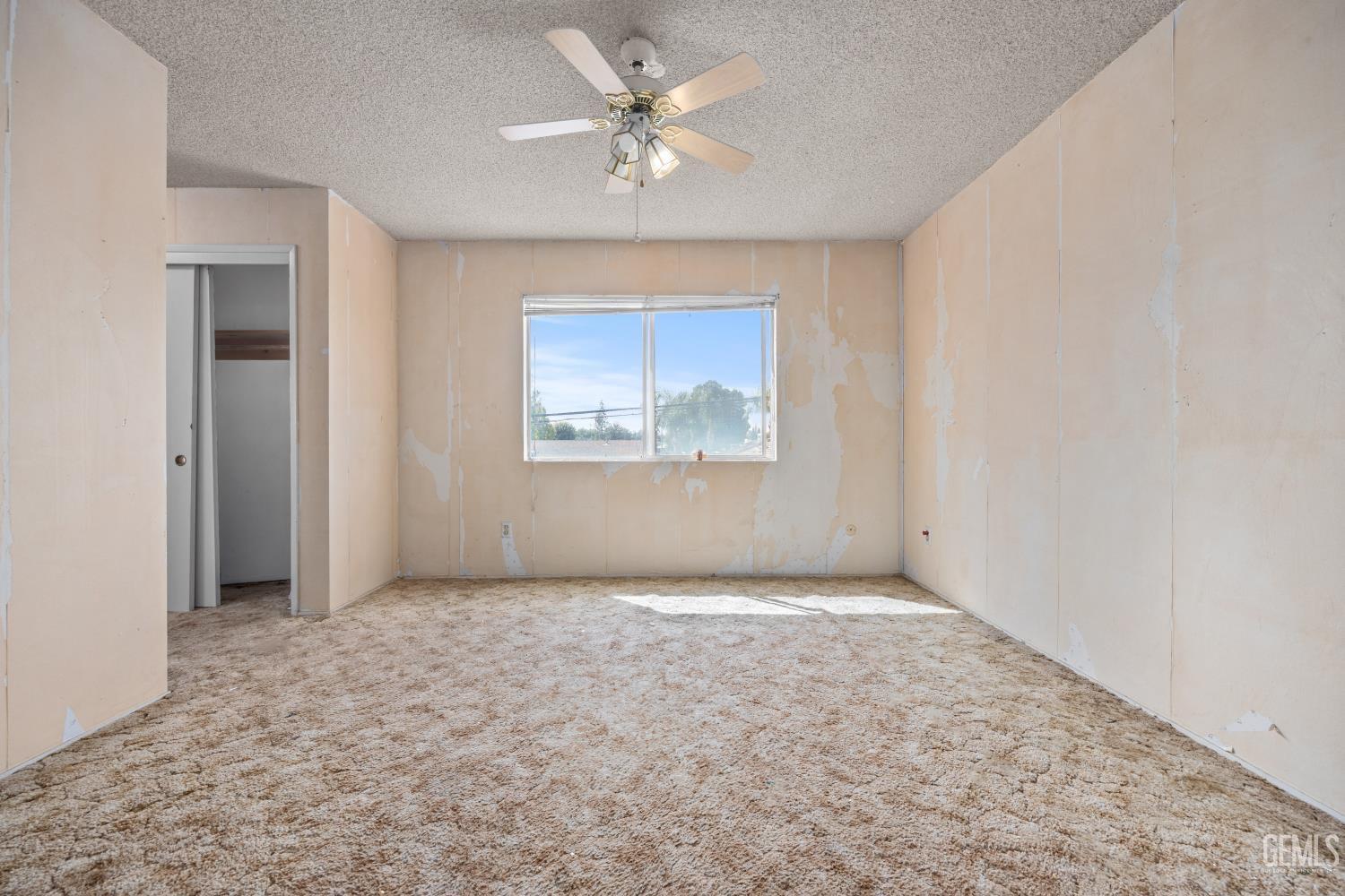 Undisclosed Address Bakersfield, CA 93309 - Photo 22 of 33 an empty room with a chandelier fan and windows