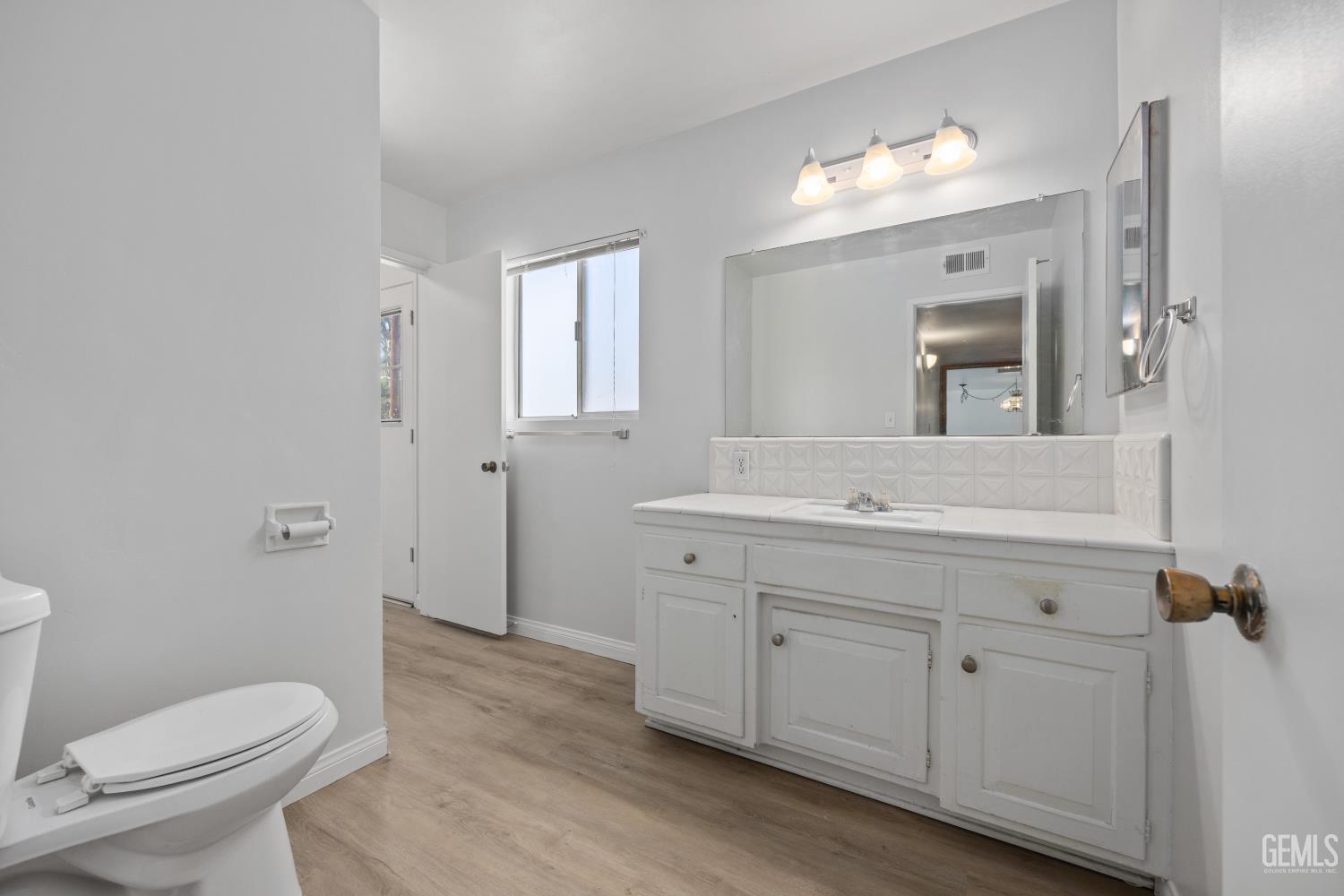 Undisclosed Address Bakersfield, CA 93309 - Photo 24 of 33 a bathroom with a toilet a sink and mirror