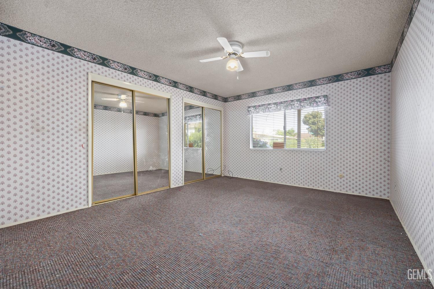 Undisclosed Address Bakersfield, CA 93309 - Photo 26 of 33 an empty room with chandelier fan and windows