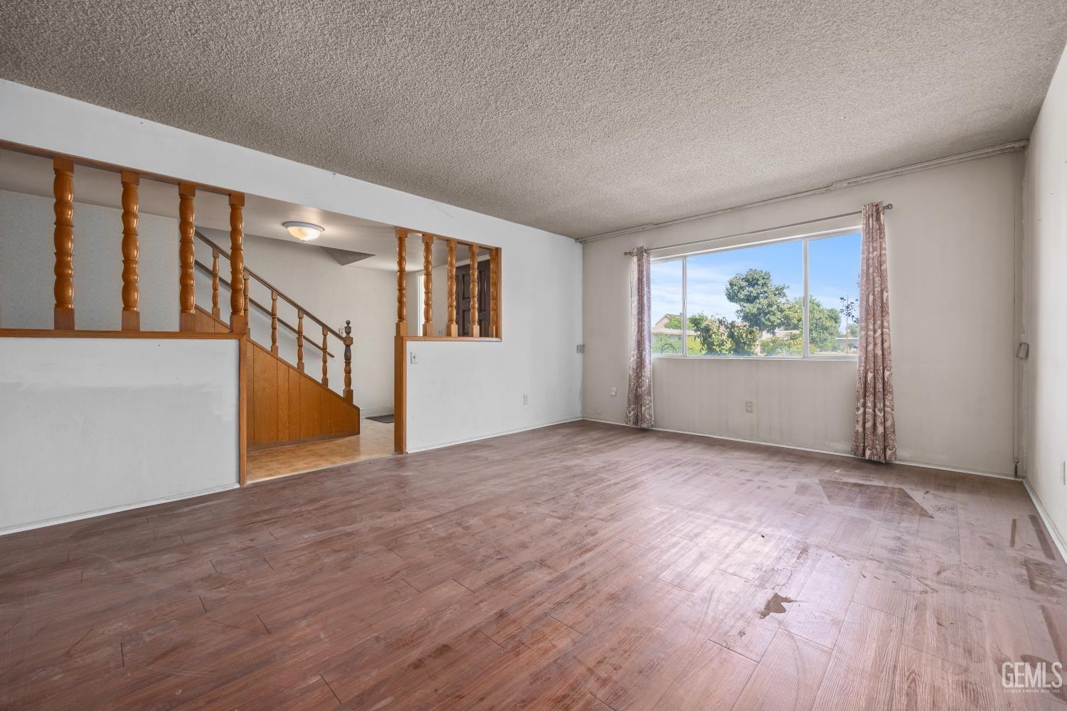Undisclosed Address Bakersfield, CA 93309 - Photo 7 of 33 a view of an empty room with window and wooden floor