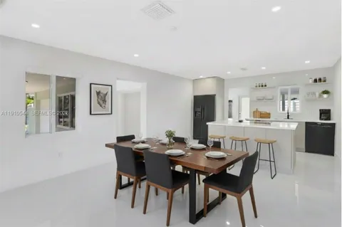 a large white kitchen with kitchen island a sink a center island and a stove