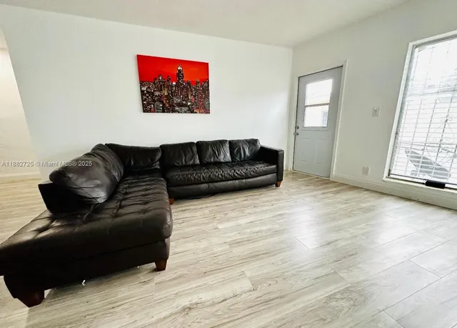a living room with furniture and a hard wood floor
