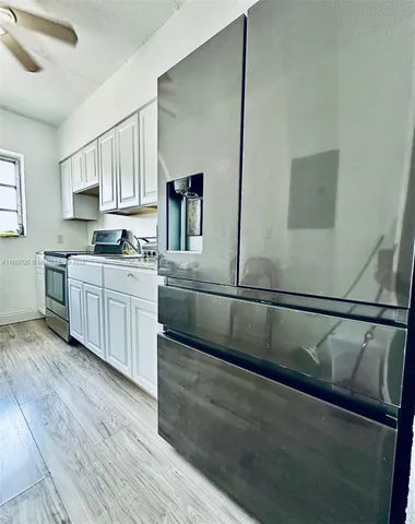 a kitchen with stainless steel appliances granite countertop a sink a stove top oven and wooden floors