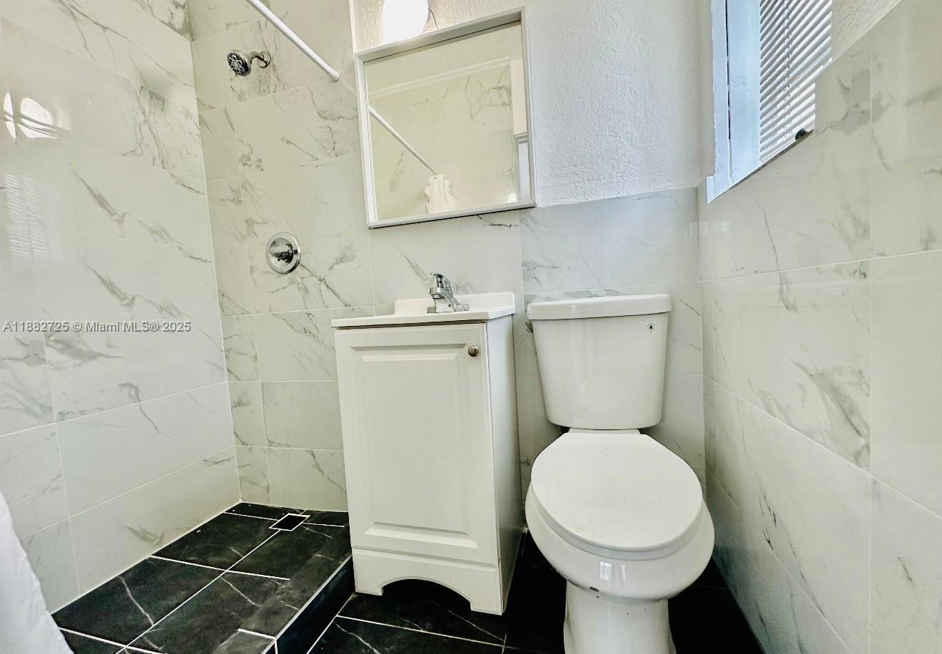 7712 Byron Avenue, Unit 3 Miami Beach, FL 33141 - Photo 8 of 8 a bathroom with a toilet and a sink