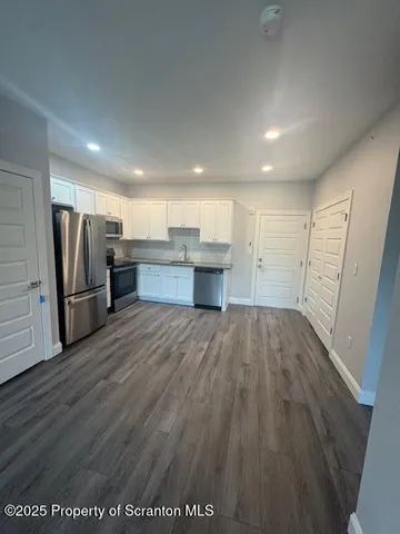 a view of a kitchen with a sink refrigerator and a window