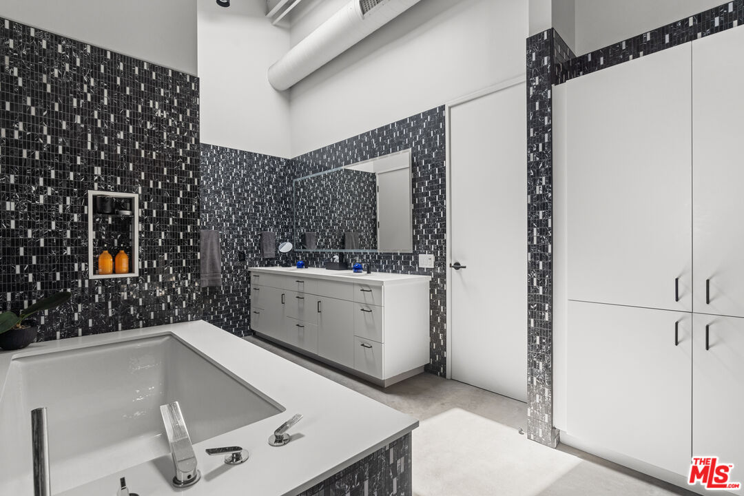 548 Rose Avenue Venice, CA 90291 - Photo 34 of 48 a bathroom with a sink a mirror and shower