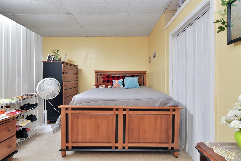 276 Broadway Lawrence, MA 01841 - Photo 13 of 27 a bedroom with a bed and wooden floor