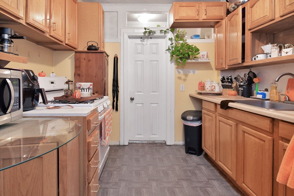 276 Broadway Lawrence, MA 01841 - Photo 19 of 27 a kitchen with stainless steel appliances a sink stove and refrigerator