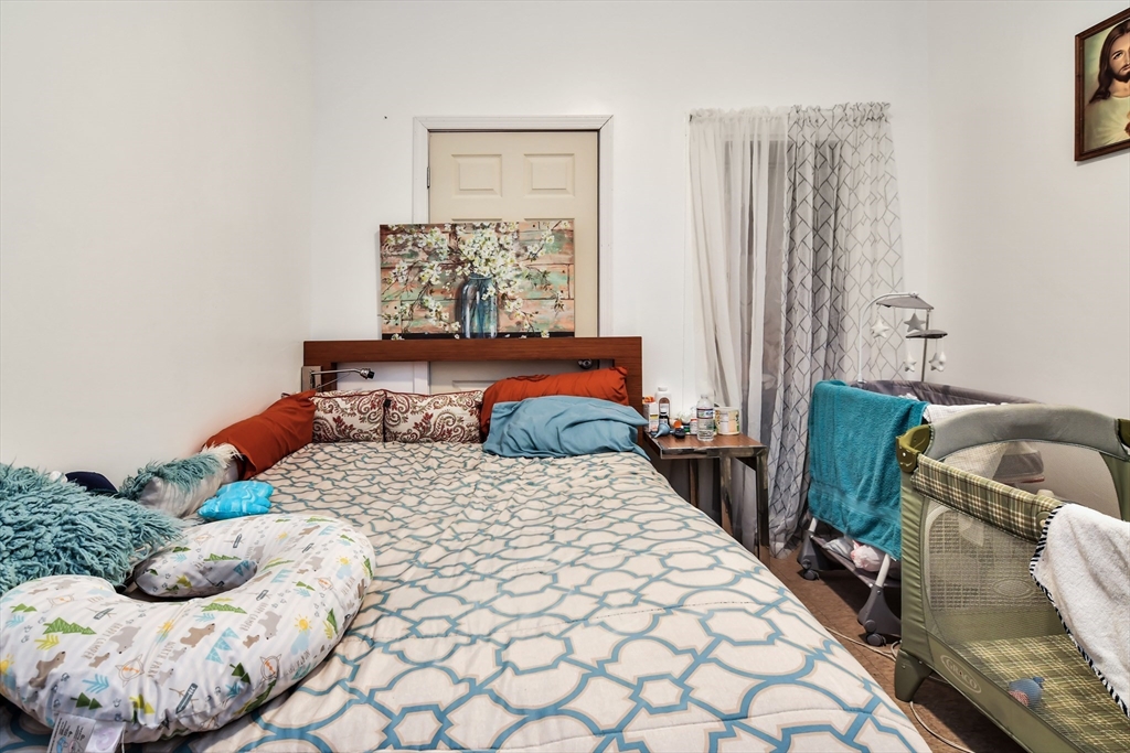 276 Broadway Lawrence, MA 01841 - Photo 21 of 27 a bedroom with a bed and a window