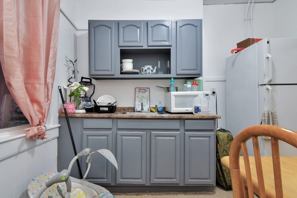 276 Broadway Lawrence, MA 01841 - Photo 22 of 27 a kitchen with a sink appliances and cabinets