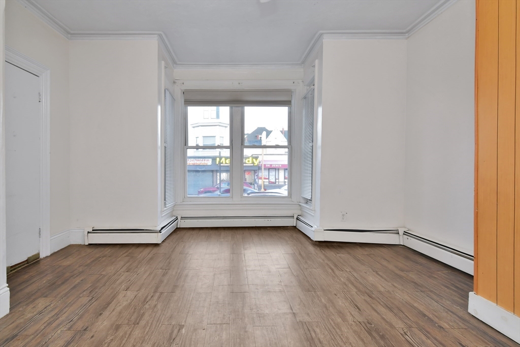 276 Broadway Lawrence, MA 01841 - Photo 5 of 27 an empty room with wooden floor and windows