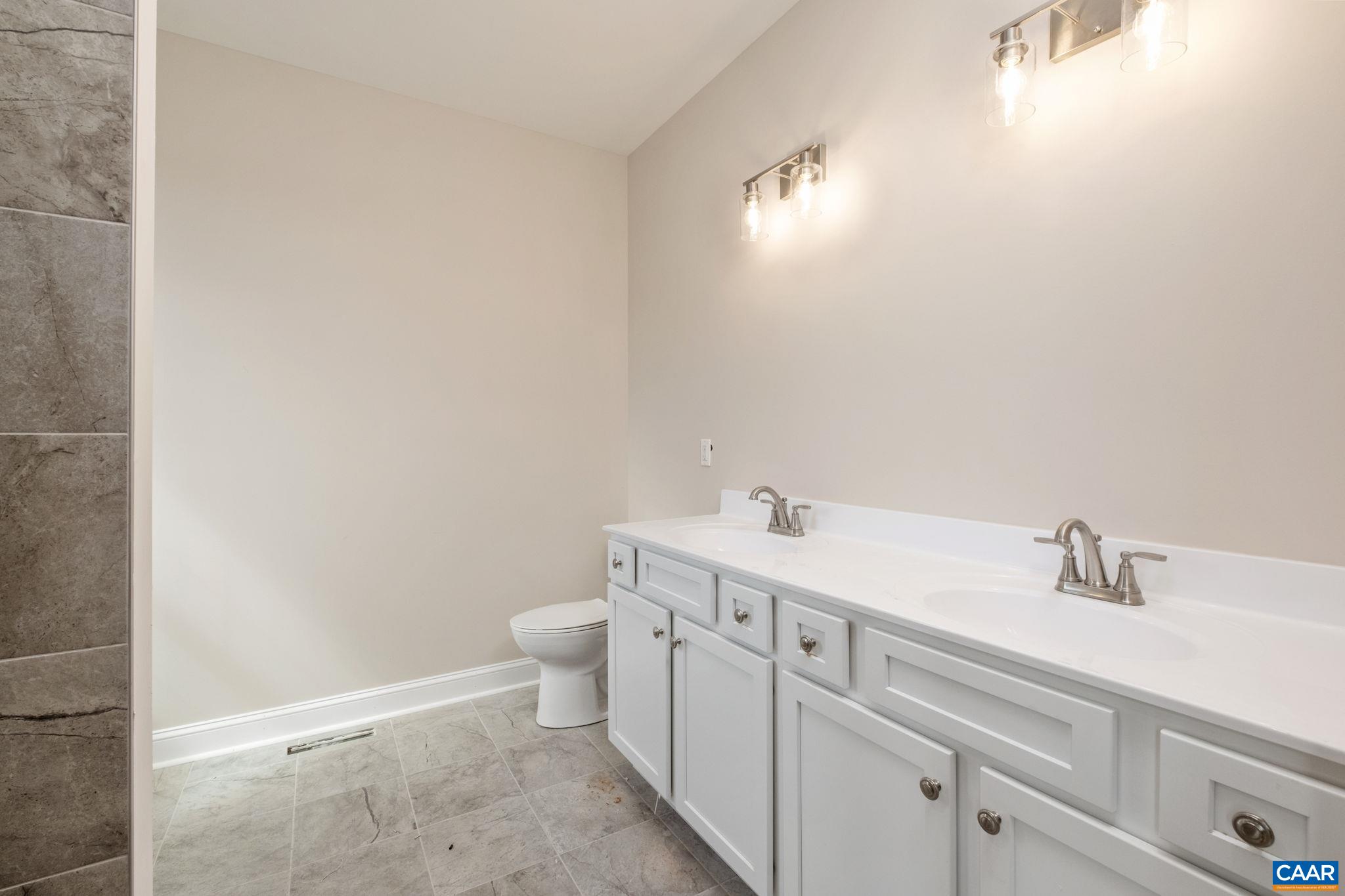1004 High Point Court Waynesboro, VA 22980 - Photo 14 of 39 The primary bathroom features dual sinks, a tiled shower, and additional space for toiletries.