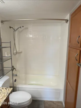 a bathroom with a granite countertop sink toilet and shower