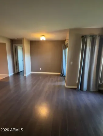 an empty room with wooden floor and mirror