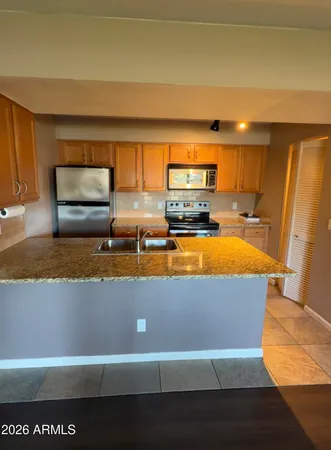 a kitchen with a sink a stove top oven and cabinetry