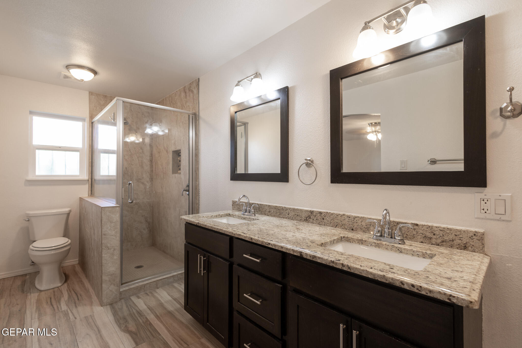 14829 Kingston Road Horizon City, TX 79928 - Photo 27 of 34 a bathroom with a granite countertop sink a toilet and a mirror