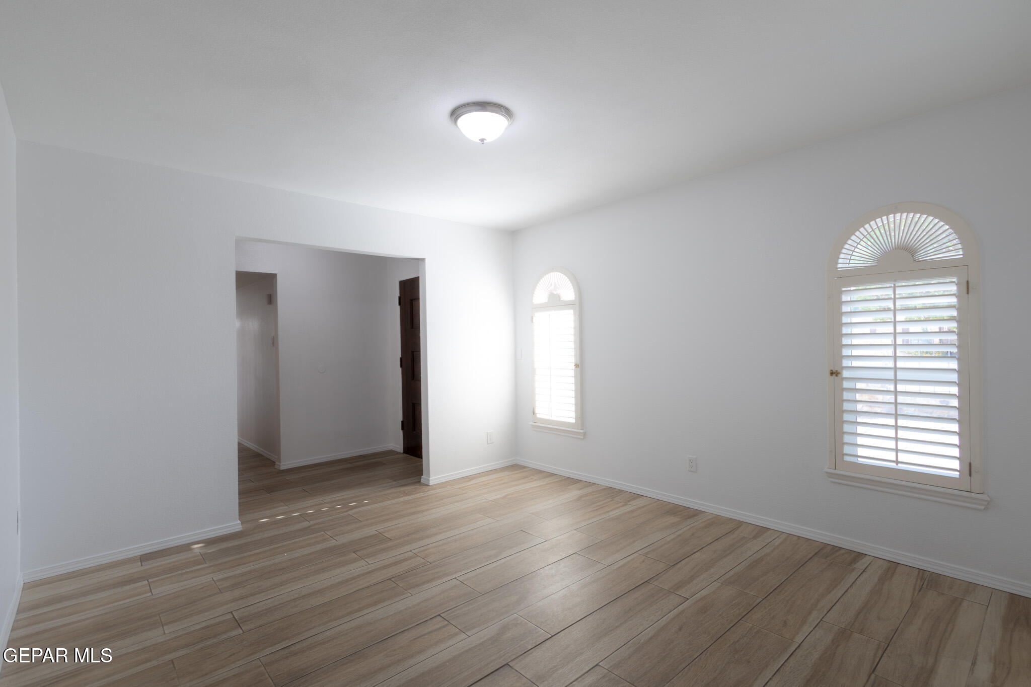 14829 Kingston Road Horizon City, TX 79928 - Photo 6 of 34 an empty room with wooden floor and windows
