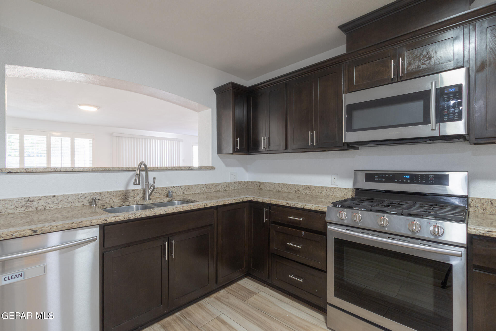 14829 Kingston Road Horizon City, TX 79928 - Photo 10 of 34 a kitchen with stainless steel appliances granite countertop a sink stove and microwave