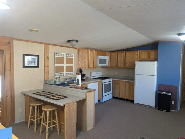 a kitchen with granite countertop a stove a sink dishwasher and a refrigerator