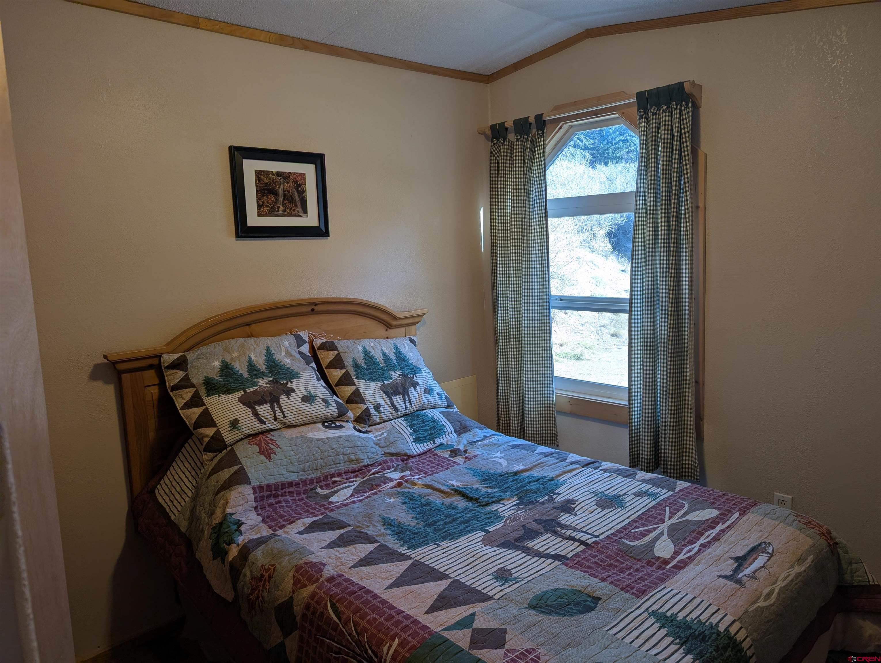 472 Haystack Circle Pagosa Springs, CO 81147 - Photo 21 of 31 a bed sitting in a bedroom next to a window