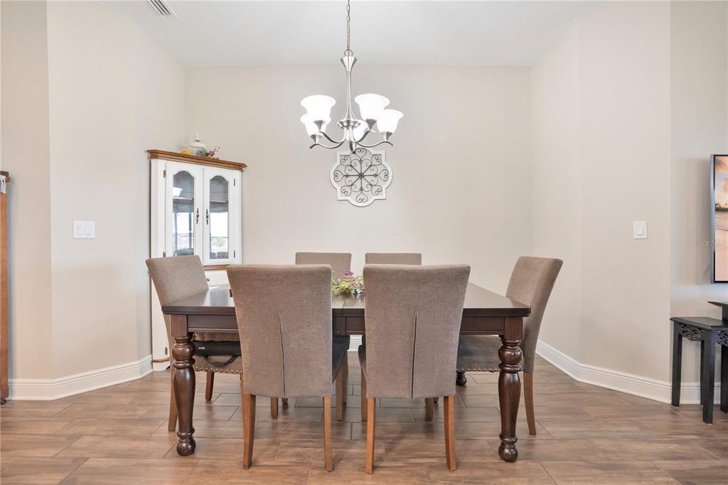 13541 Circa Crossing Drive Lithia, FL 33547 - Photo 12 of 52 a dining room with furniture a chandelier and wooden floor