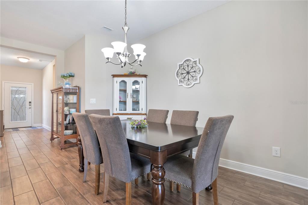 13541 Circa Crossing Drive Lithia, FL 33547 - Photo 13 of 52 a view of a dining room with furniture a chandelier and wooden floor