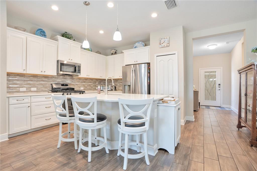 13541 Circa Crossing Drive Lithia, FL 33547 - Photo 14 of 52 a kitchen with stainless steel appliances kitchen island granite countertop a refrigerator and microwave