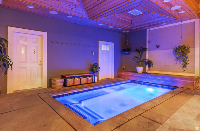 912 North Loafer Canyon Road Elk Ridge, UT 84651 - Photo 88 of 98 Indoor plunge pool with blue tile detailing, concrete surround, and a wood-paneled ceiling