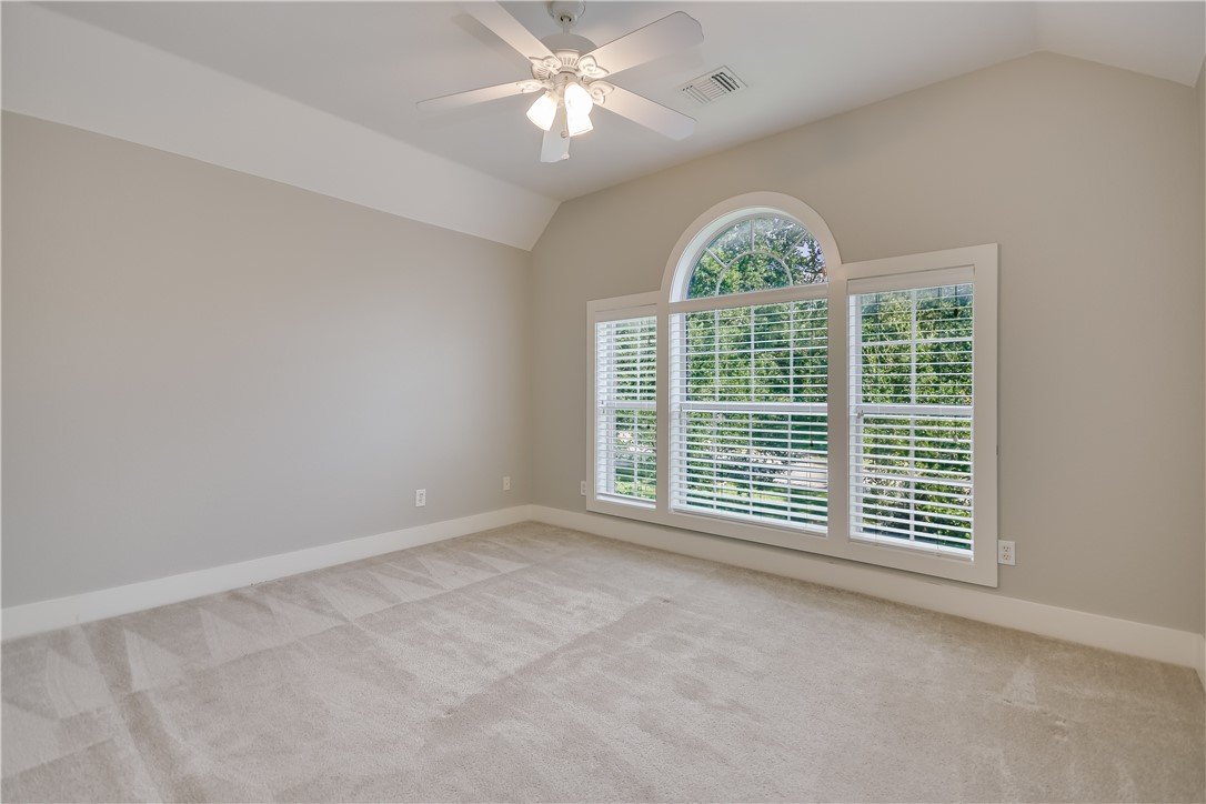 3513 Grimes Ranch Road Austin, TX 78732 - Photo 16 of 32 Spare room with vaulted ceiling, light colored carpet, baseboards, and a ceiling fan