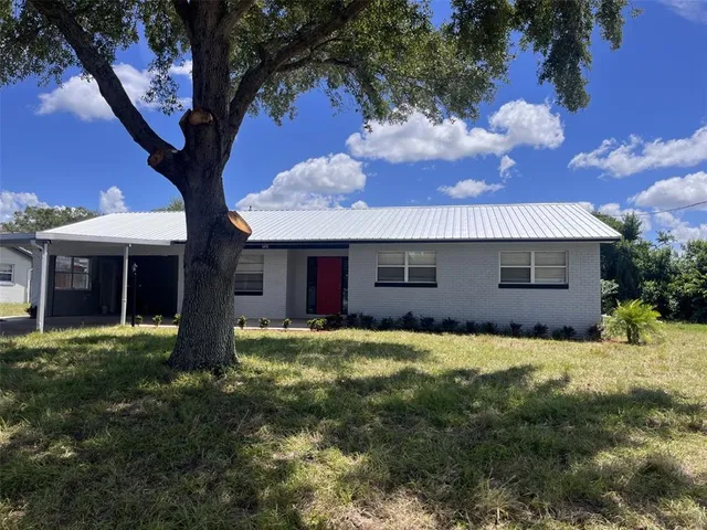 a view of a yard in front of house with a large tree