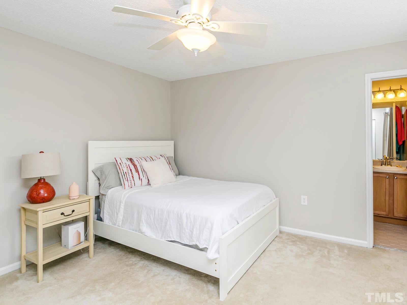 7738 Falcon Rest Circle Raleigh, NC 27615 - Photo 12 of 18 a bedroom with a bed and a chandelier