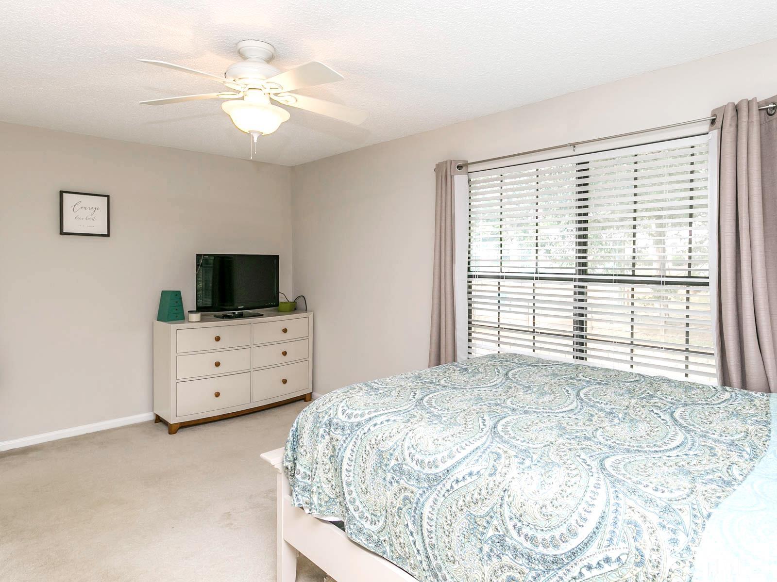 7738 Falcon Rest Circle Raleigh, NC 27615 - Photo 13 of 18 a bedroom with a bed and a flat screen tv
