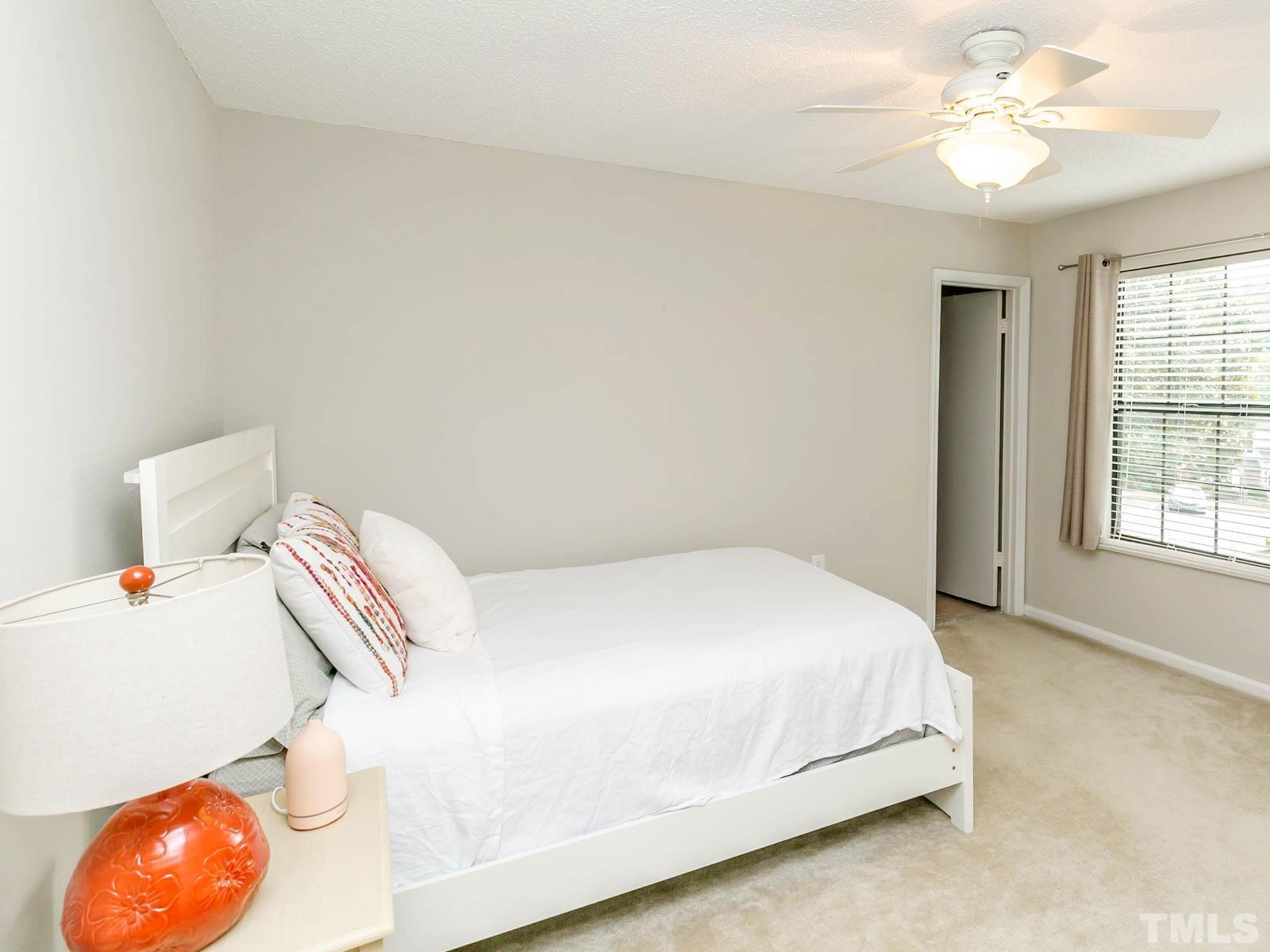 7738 Falcon Rest Circle Raleigh, NC 27615 - Photo 14 of 18 a bedroom with a bed and a chandelier
