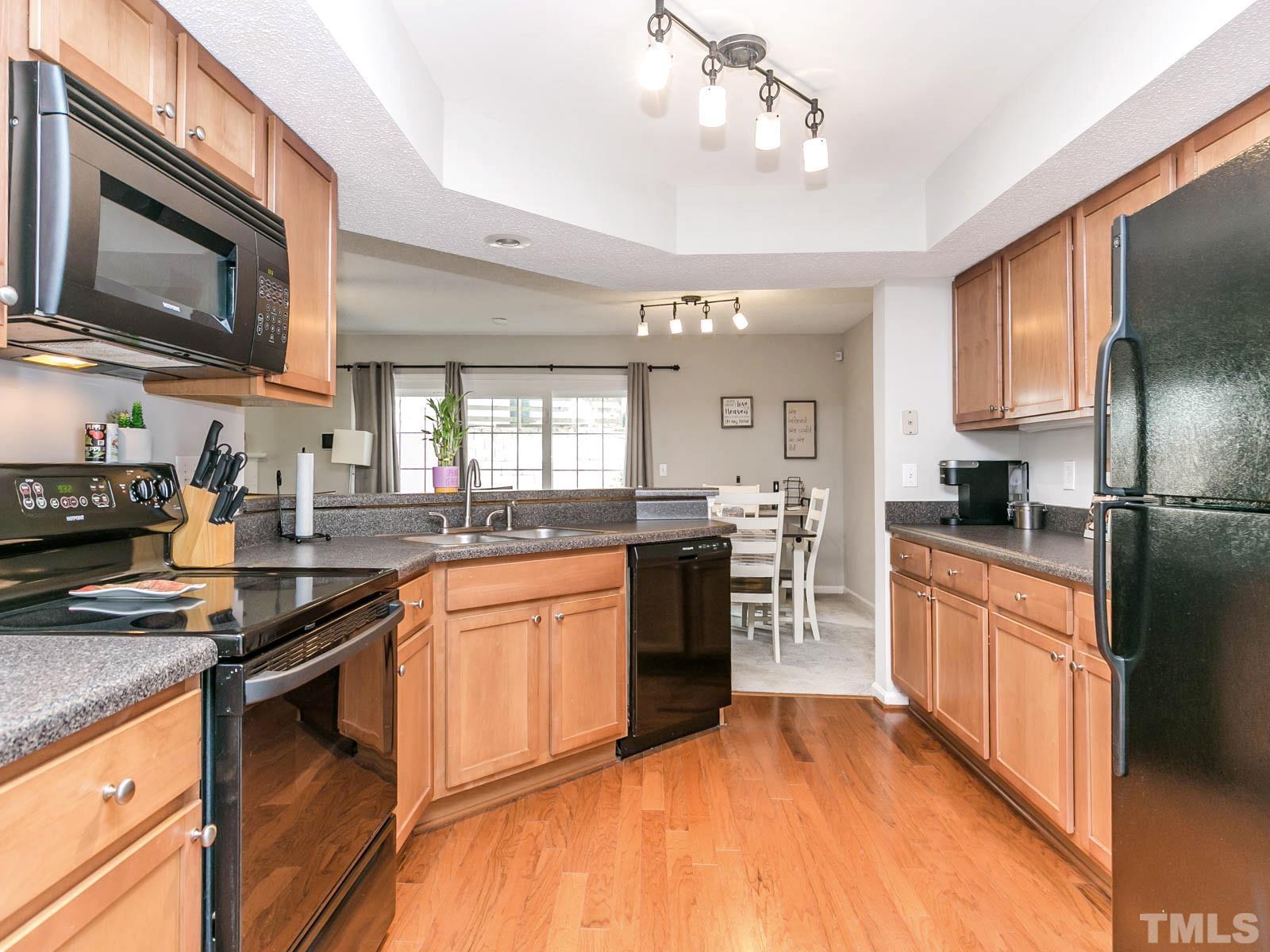 7738 Falcon Rest Circle Raleigh, NC 27615 - Photo 3 of 18 a kitchen with stainless steel appliances granite countertop a sink stove microwave and refrigerator