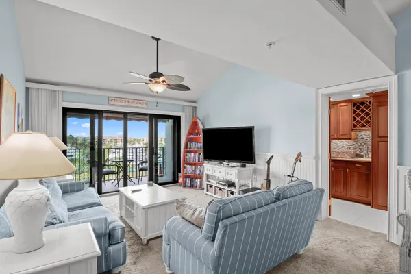 a living room with furniture a flat screen tv and a large window
