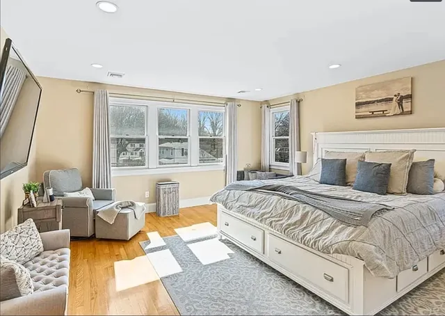 a spacious bedroom with a bed and glass window