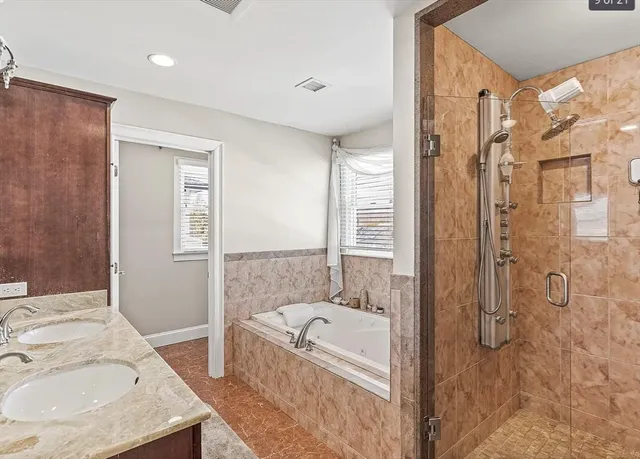 a bathroom with a granite countertop sink a mirror and a bathtub